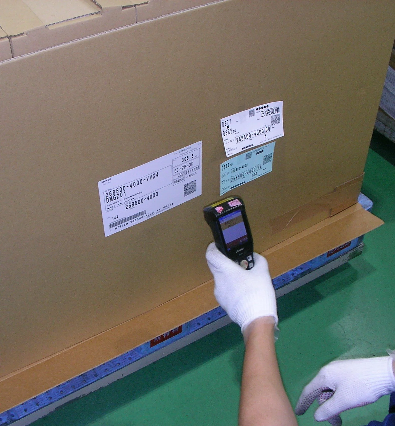 出荷用パレットの段ボール箱をラップで固定する物流作業